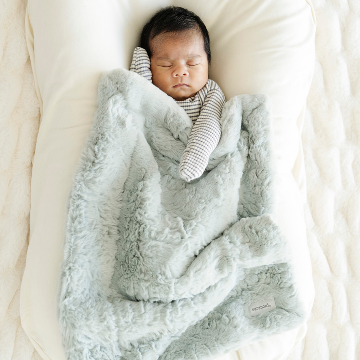 Baby Boy snuggled with Sweet Mint Dream Mini Baby Blanket.