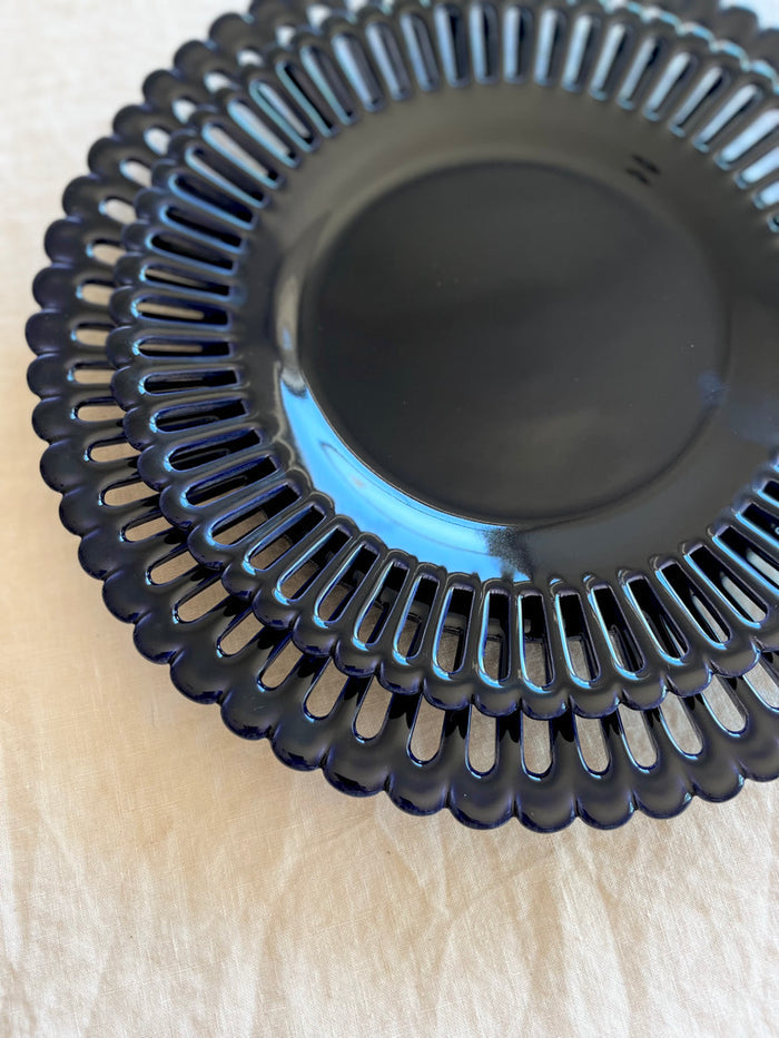dark blue dinner plate with openwork rim and scalloped edge detail view