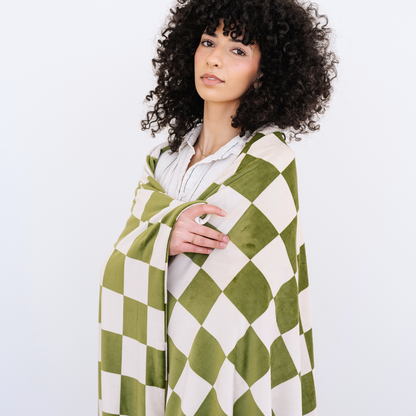 Woman wrapped in a Olive and cream checkered minky stretch blanket.