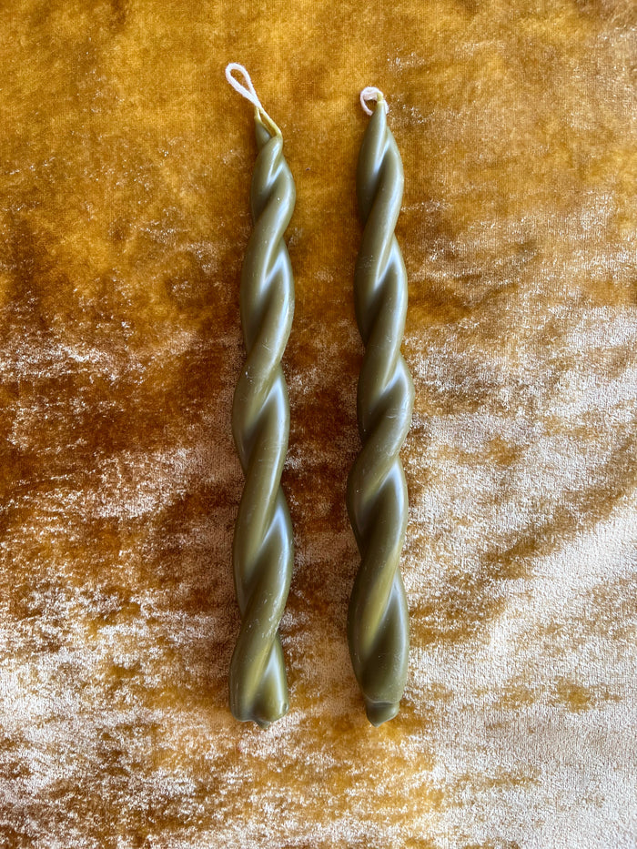 moss green twisted taper candles by wax atelier on gold velvet