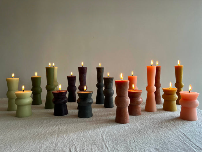 small terra totem candle with assorted colors and flames lit
